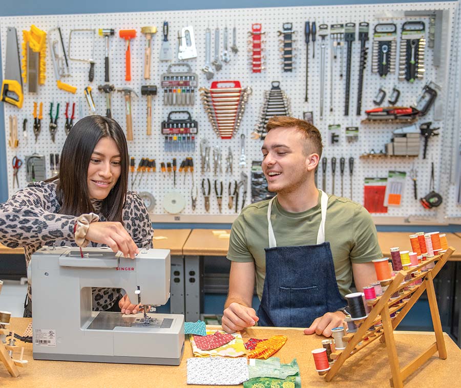 Two students using the sewing machine in the innovation lab.